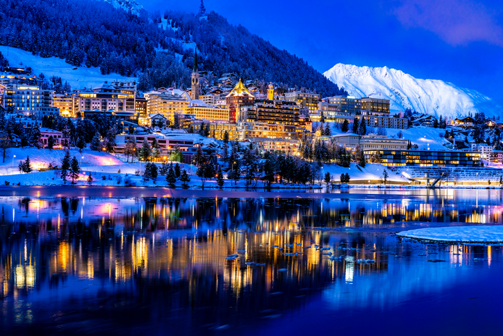 View of beautiful night lights of St. Moritz in Switzerland at night, with reflection from the lake and snow mountains in backgrouind St.Moritz Switzerland